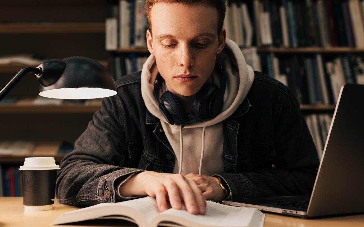 Male student reading from a book