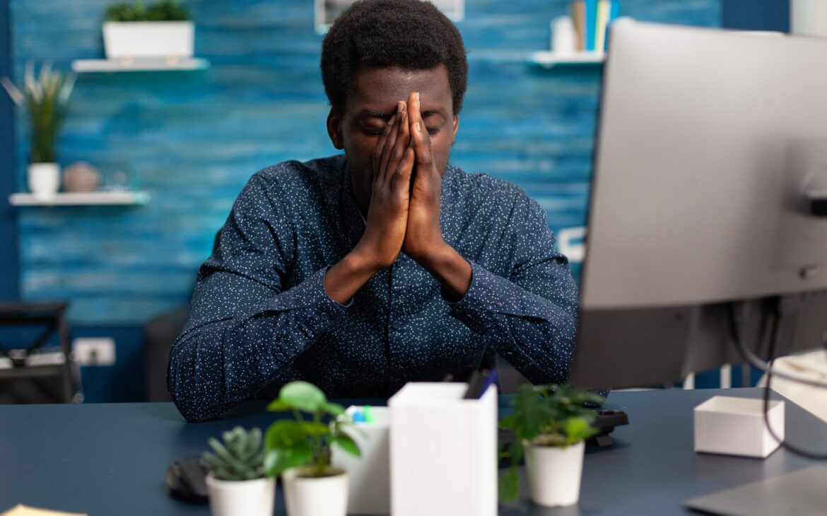 Sick african american guy stressing about deadline